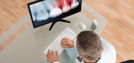 Dentist looking at an X-Ray on a computer screen